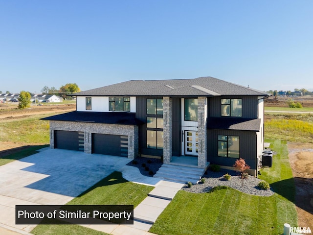 view of front of house with a garage, concrete driveway, french doors, and a shingled roof