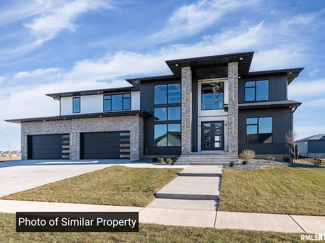 modern home featuring a garage, driveway, and a front lawn