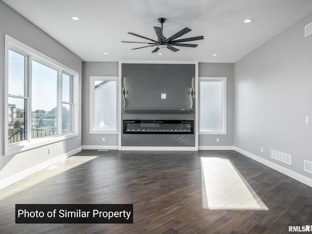 unfurnished living room with dark wood-style floors, a fireplace, recessed lighting, visible vents, and baseboards