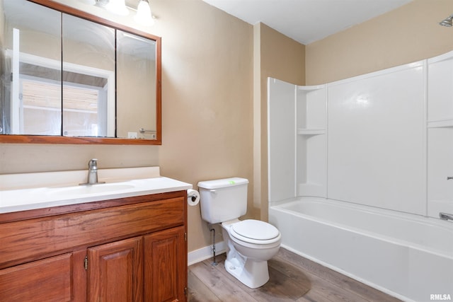 full bath featuring baseboards, toilet, shower / tub combination, wood finished floors, and vanity