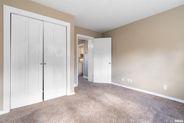 unfurnished bedroom featuring a closet, carpet, and baseboards