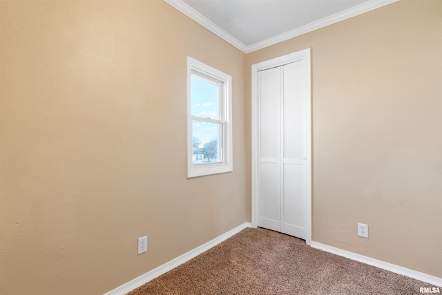 unfurnished bedroom with ornamental molding, a closet, carpet flooring, and baseboards