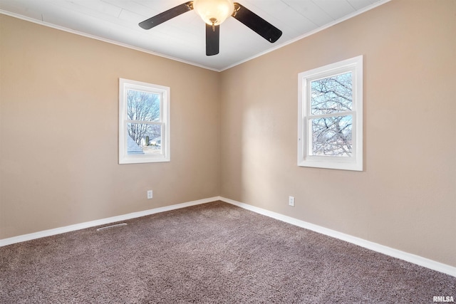 spare room with carpet, baseboards, ceiling fan, and ornamental molding