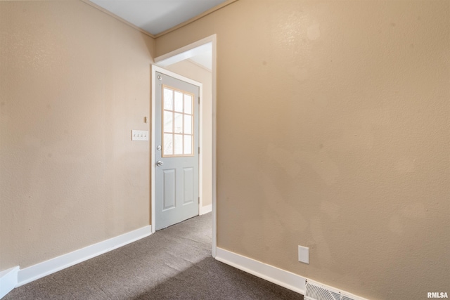 spare room with dark colored carpet and baseboards