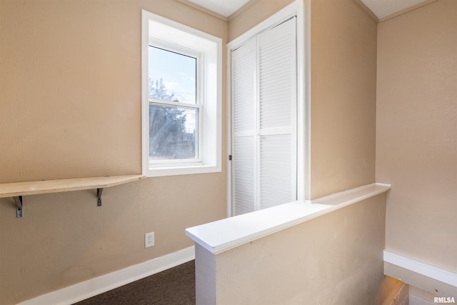 hall with carpet floors and baseboards