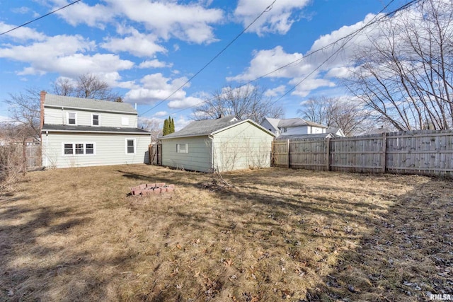 rear view of property with an outbuilding, fence, a chimney, and a lawn