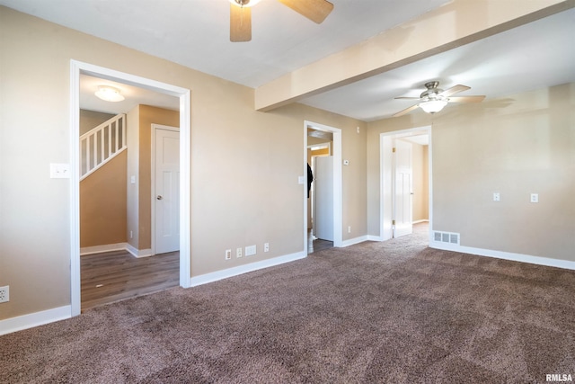 spare room with carpet flooring, visible vents, and baseboards