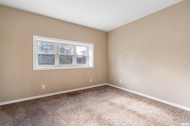 carpeted spare room featuring baseboards