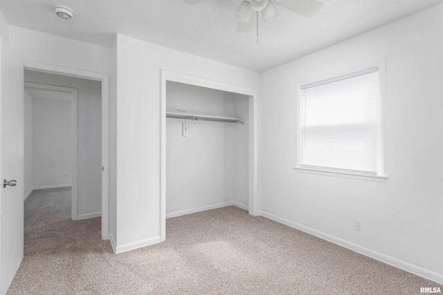 unfurnished bedroom featuring a ceiling fan, a closet, carpet flooring, and baseboards