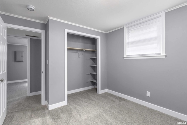 unfurnished bedroom with carpet floors, ornamental molding, a closet, and baseboards