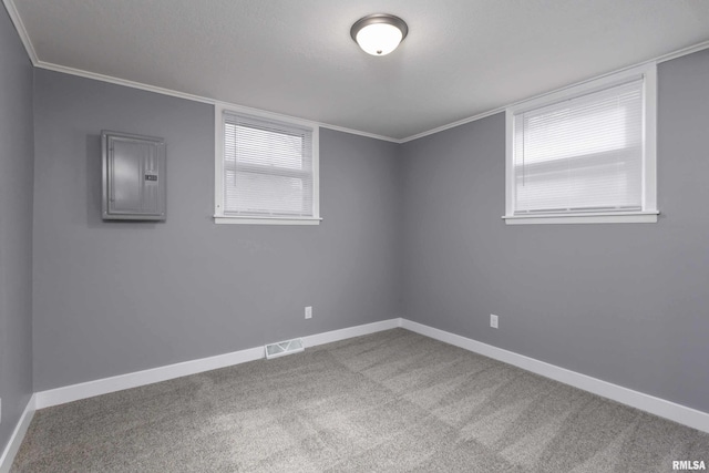 spare room featuring a textured ceiling, carpet flooring, visible vents, baseboards, and electric panel