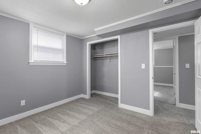 unfurnished bedroom featuring carpet, a closet, a textured ceiling, and baseboards