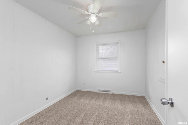 carpeted empty room featuring a ceiling fan, visible vents, ornamental molding, and baseboards