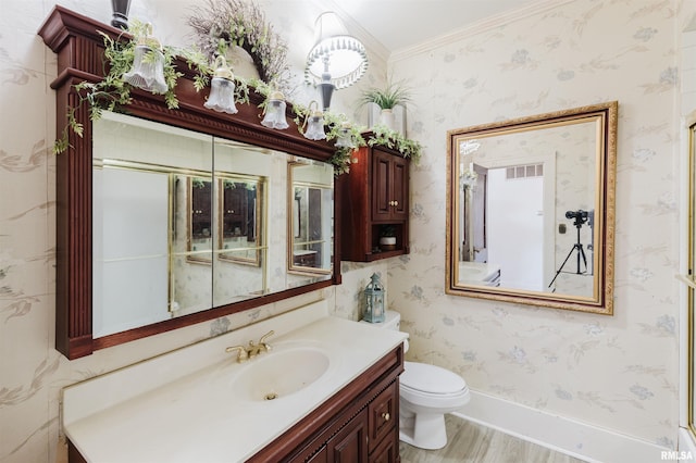 bathroom featuring baseboards, vanity, toilet, and wallpapered walls