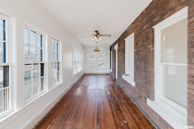 unfurnished sunroom with ceiling fan