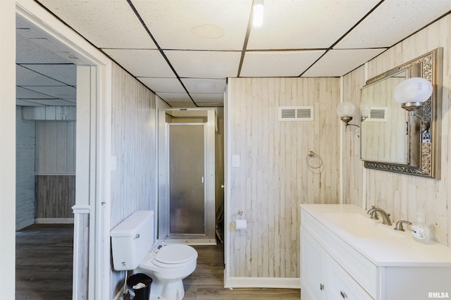 full bathroom with toilet, a stall shower, wood finished floors, and visible vents