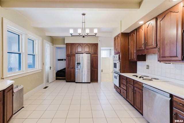 kitchen with beam ceiling, light countertops, backsplash, an inviting chandelier, and appliances with stainless steel finishes