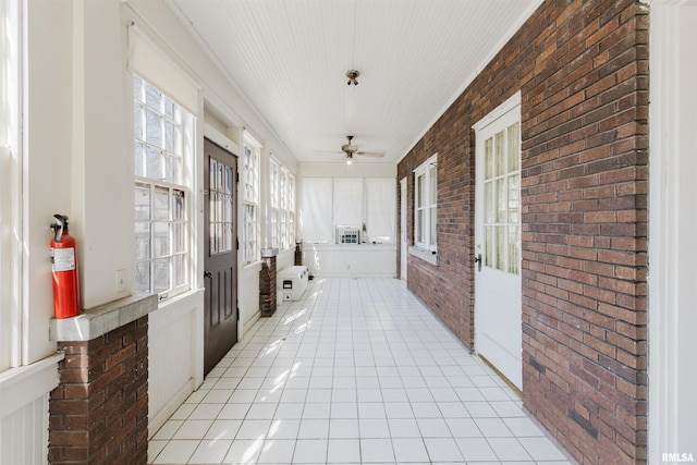 unfurnished sunroom with a ceiling fan