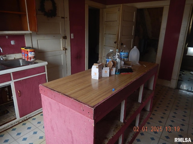 kitchen featuring light floors and a sink