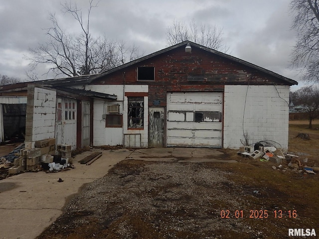 view of home's exterior with driveway and concrete block siding