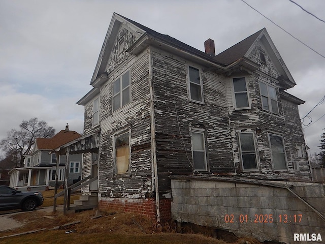 view of front of house featuring entry steps and a chimney