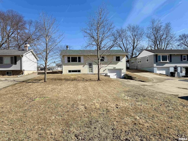 bi-level home with concrete driveway and an attached garage