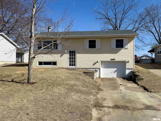 rear view of house featuring an attached garage and concrete driveway