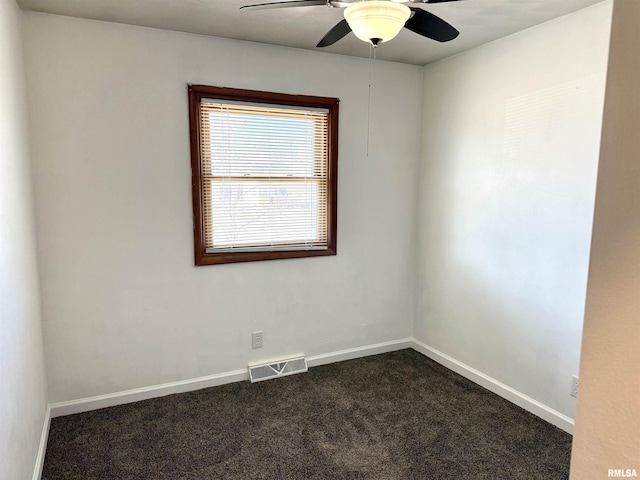 unfurnished room featuring visible vents, dark carpet, baseboards, and ceiling fan