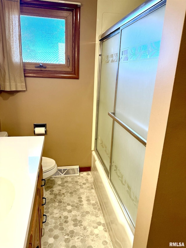 full bath featuring baseboards, visible vents, toilet, enclosed tub / shower combo, and vanity