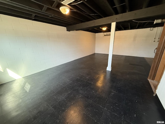 below grade area with concrete block wall and tile patterned floors