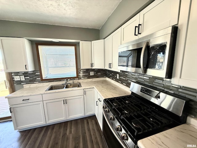 kitchen with white cabinets, dark wood-type flooring, stainless steel appliances, and a sink