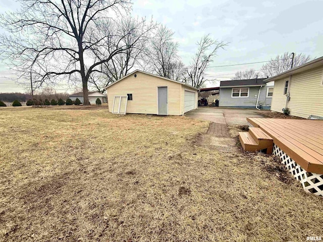 view of yard with an outdoor structure, a wooden deck, and a detached garage