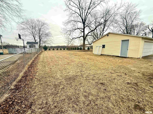 view of yard with a garage, fence, and an outdoor structure