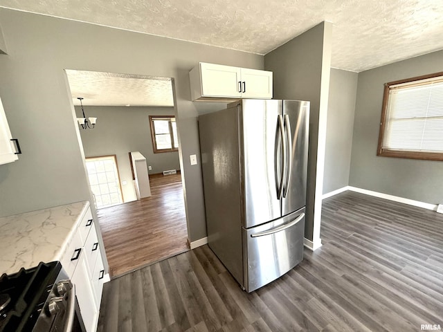 kitchen with a textured ceiling, appliances with stainless steel finishes, dark wood finished floors, and white cabinets