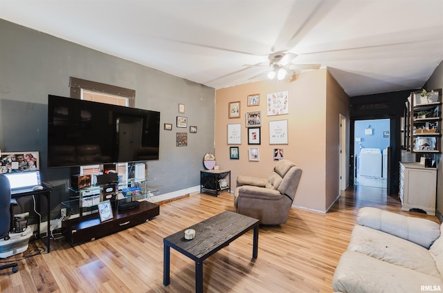 living room with washer / dryer, a ceiling fan, and wood finished floors