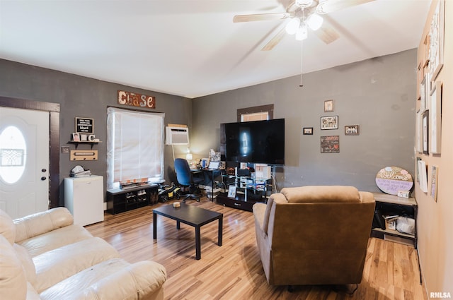 living room featuring an AC wall unit, wood finished floors, and a ceiling fan