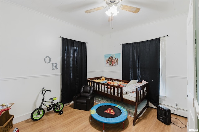 bedroom featuring ornamental molding, a ceiling fan, and wood finished floors