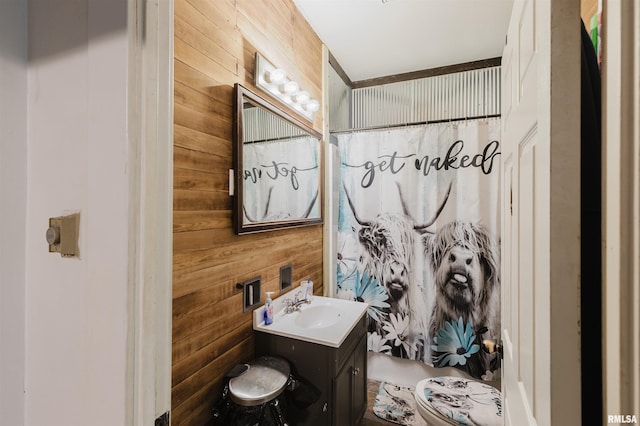 full bathroom with toilet, curtained shower, wooden walls, and vanity