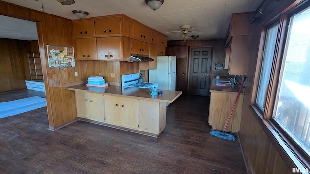 kitchen with ceiling fan, wooden walls, white appliances, and under cabinet range hood