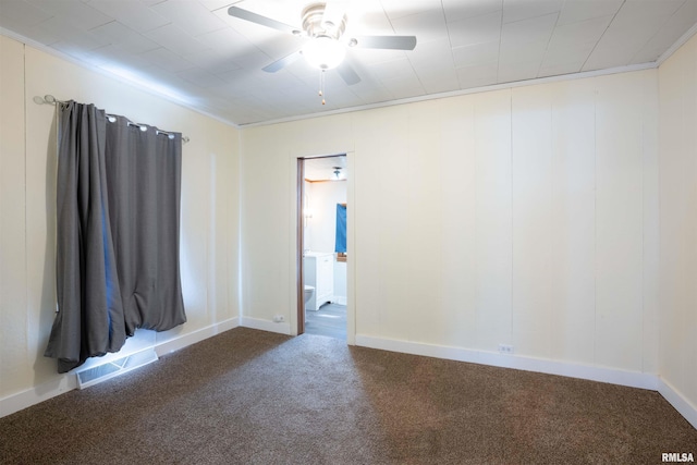 empty room featuring ceiling fan, carpet flooring, visible vents, baseboards, and ornamental molding