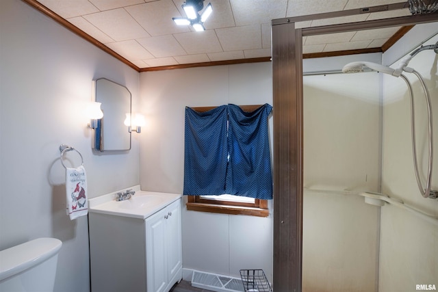 bathroom featuring ornamental molding, vanity, toilet, and walk in shower