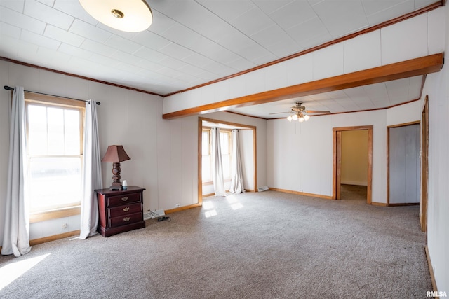 unfurnished room featuring carpet, plenty of natural light, baseboards, and crown molding