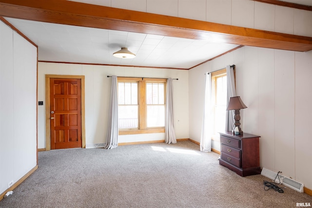 spare room with carpet floors, visible vents, ornamental molding, and baseboards