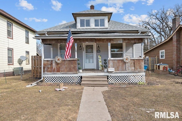 bungalow with covered porch, fence, and roof with shingles