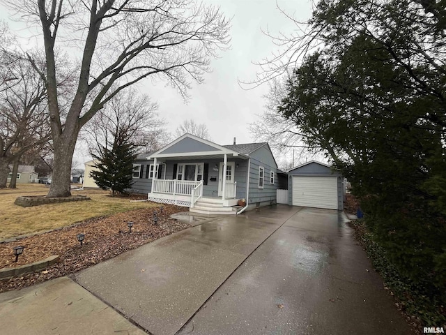 bungalow-style home featuring a garage, driveway, a porch, and an outdoor structure