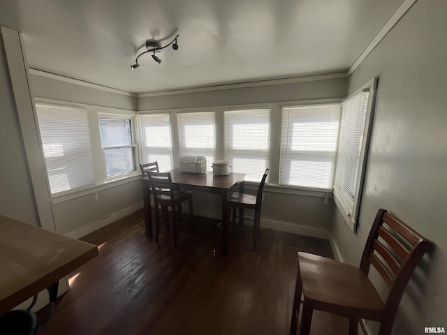 dining room with baseboards, wood finished floors, and ornamental molding