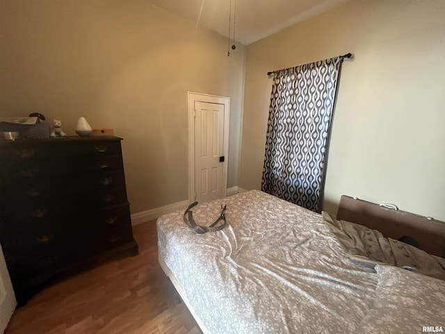 bedroom with baseboards and wood finished floors