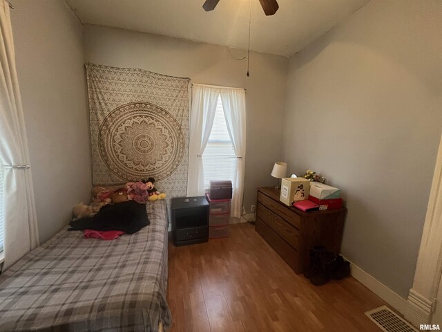 bedroom with baseboards, visible vents, ceiling fan, and wood finished floors