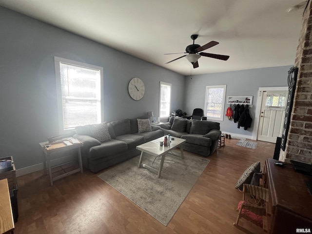 living room featuring a ceiling fan, baseboards, and wood finished floors