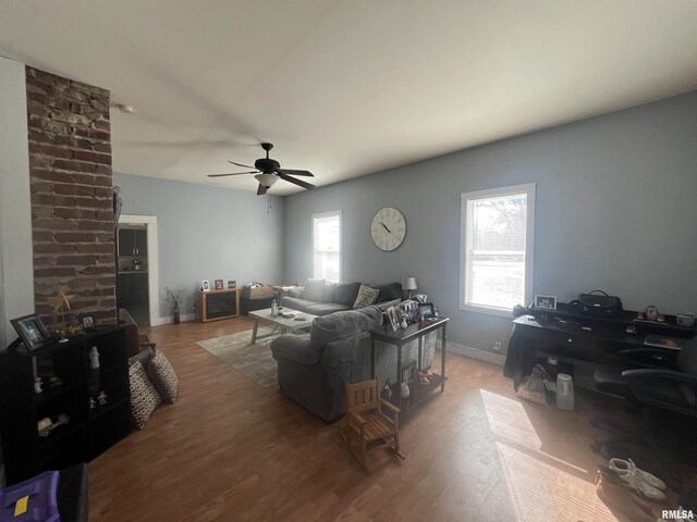 living room with a healthy amount of sunlight, a ceiling fan, baseboards, and wood finished floors